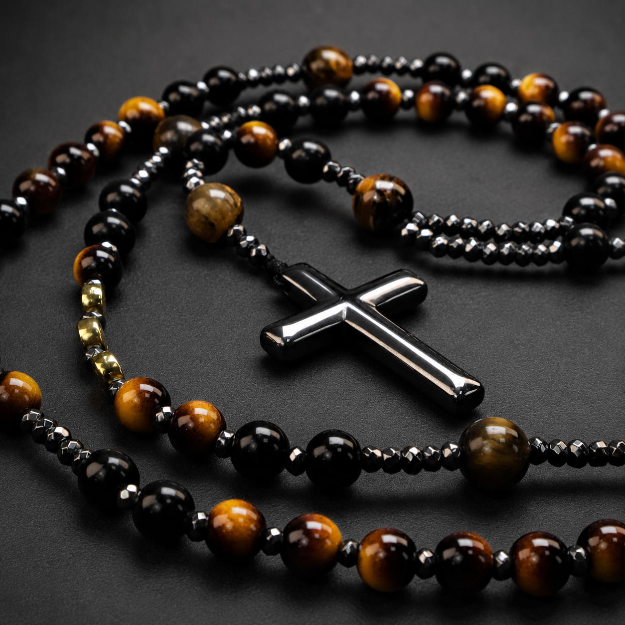 Close-up of handmade men's Catholic rosary featuring black stone beads, metallic accents, and detailed crucifix craftsmanship.