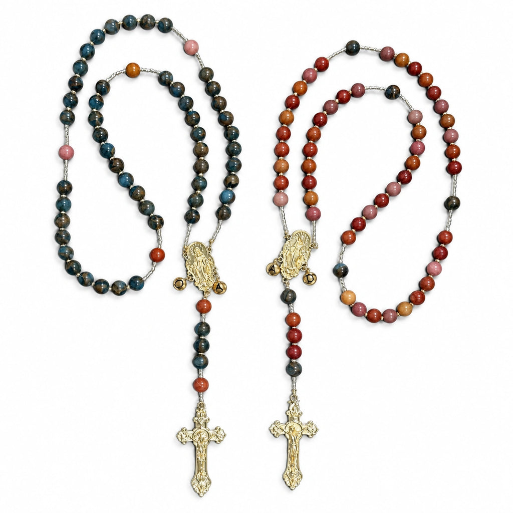 Handmade Catholic bride and groom rosary set with warm beads, Marian centerpieces, letter charms, and gold crucifix pendants.