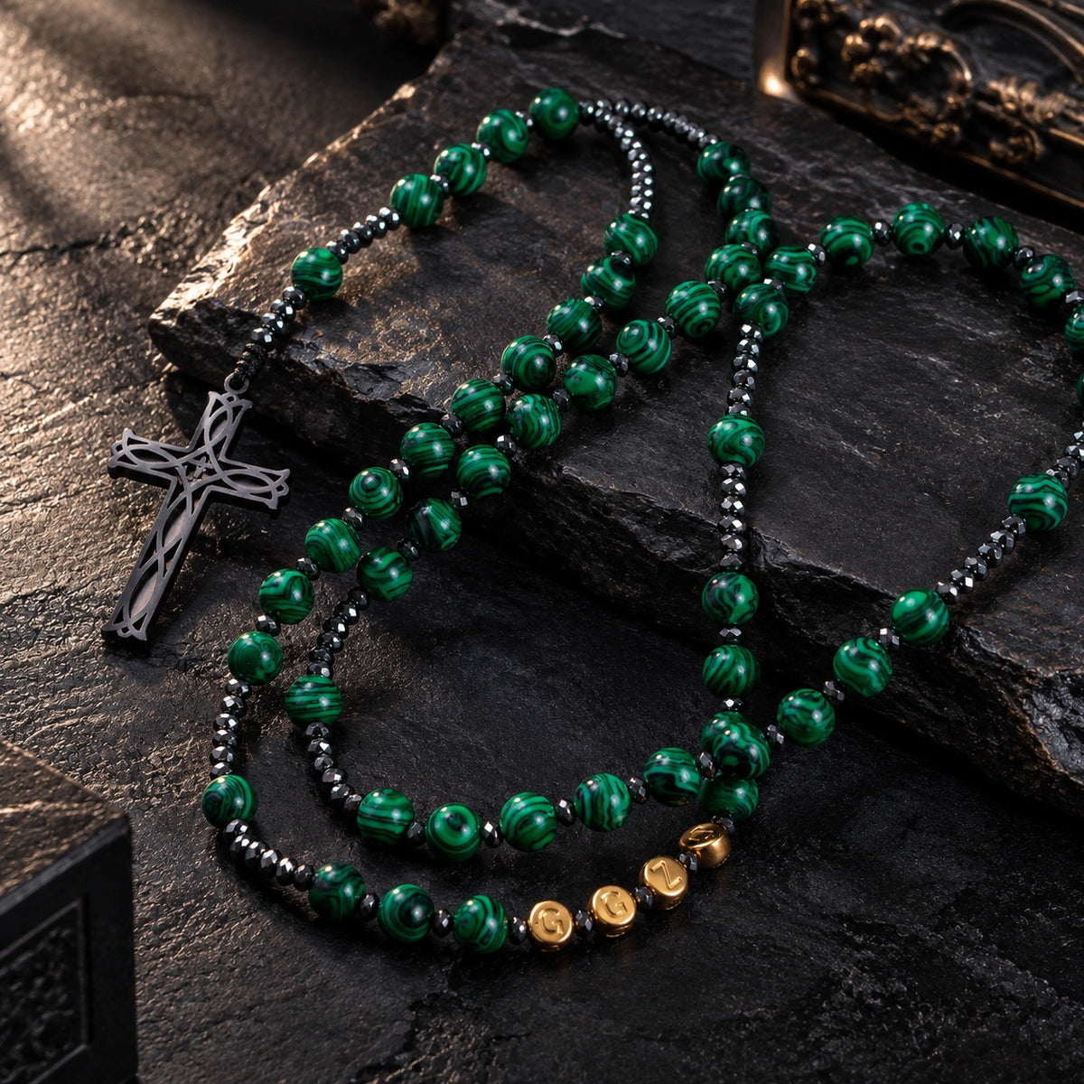 Green Stone Rosary featuring rich green swirl beads, dark metallic accents, gold letter beads, and a silver cross pendant.