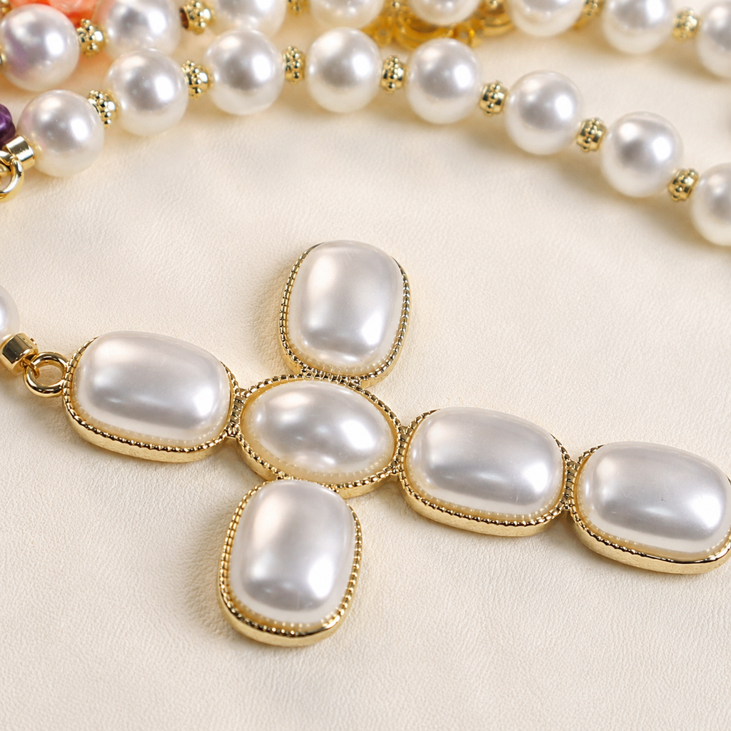 Close-up of pearl-style beads and floral accents on a handmade Catholic wedding rosary for bride and groom.
