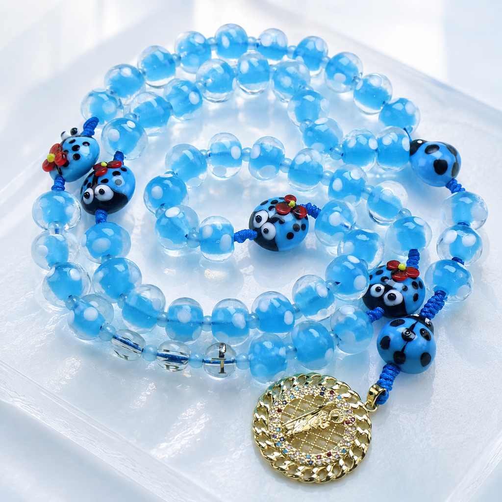 Blue glass bead Catholic rosary with playful ladybug charms and a gold religious centerpiece, a unique prayer gift for everyday devotion.