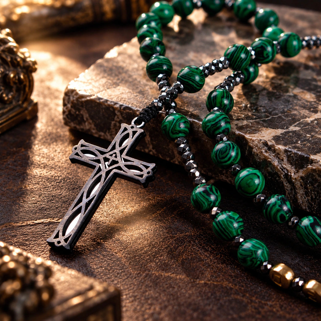Close-up of a silver crucifix pendant on a handmade men’s Catholic rosary with green stone-style prayer beads.