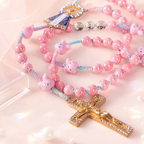 Gold cross pendant on a handmade pink Catholic rosary with bunny charms and soft beads for prayer and devotion.