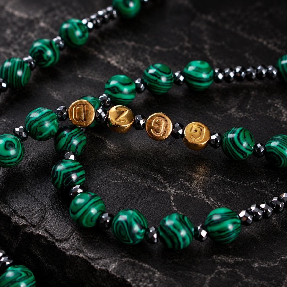 Men’s Catholic prayer beads with green natural stone-style patterns, dark metal spacer beads, and handmade rosary details.