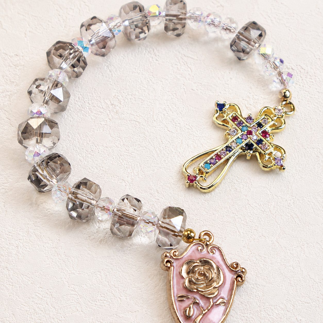 Smoky crystal Catholic prayer beads with colorful cross pendant and floral religious charm for prayer, devotion, and daily inspiration.