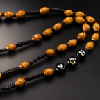 Detailed view of brown wooden-style rosary beads with dark cord knots and traditional Catholic craftsmanship.