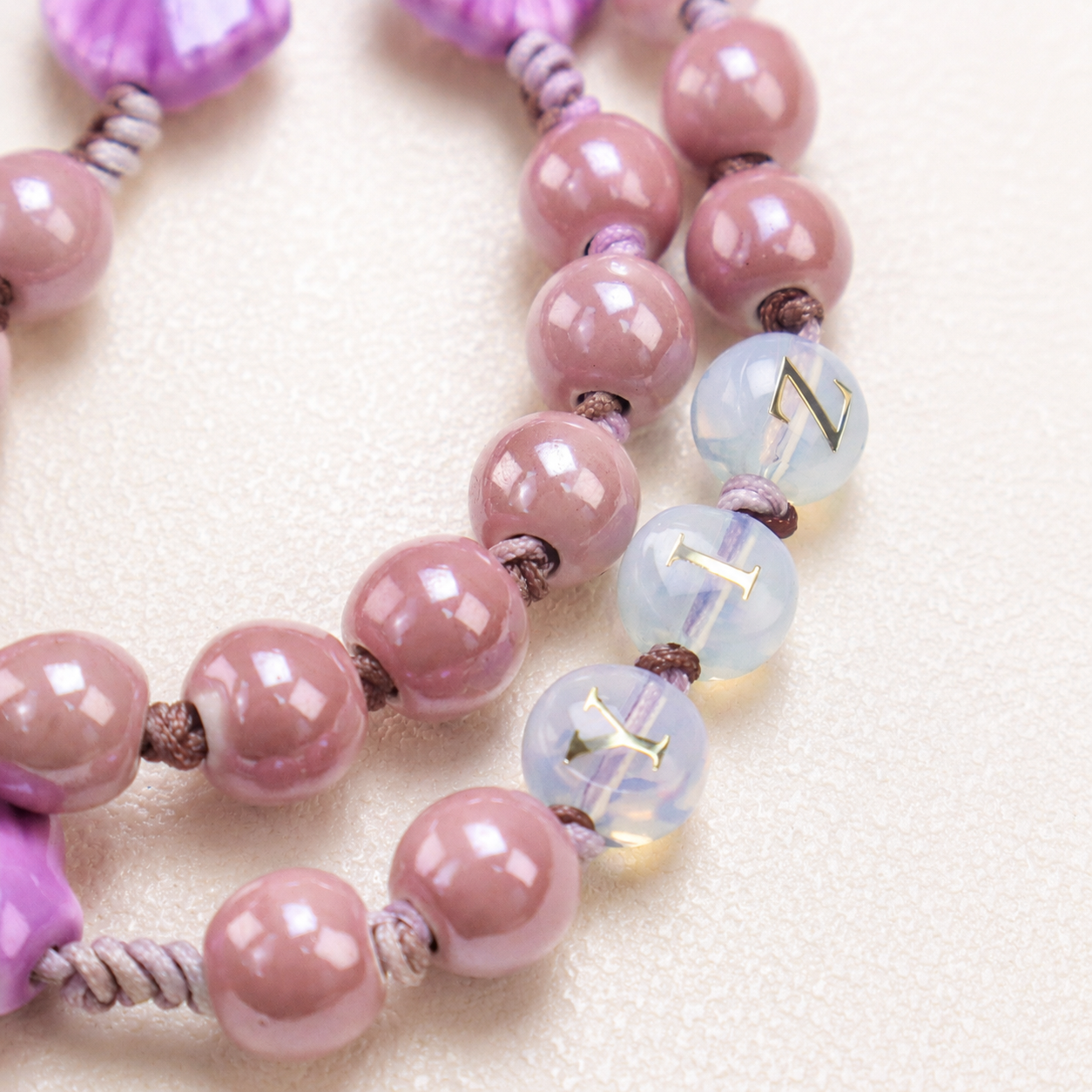 Close-up of shell-shaped beads on a handmade Catholic rosary with woven cord details and meaningful religious charms.
