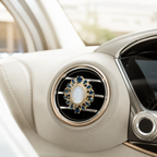 Close-up of a Catholic Virgin Mary car vent clip featuring blue crystal gemstones, gold tone frame, and elegant religious design