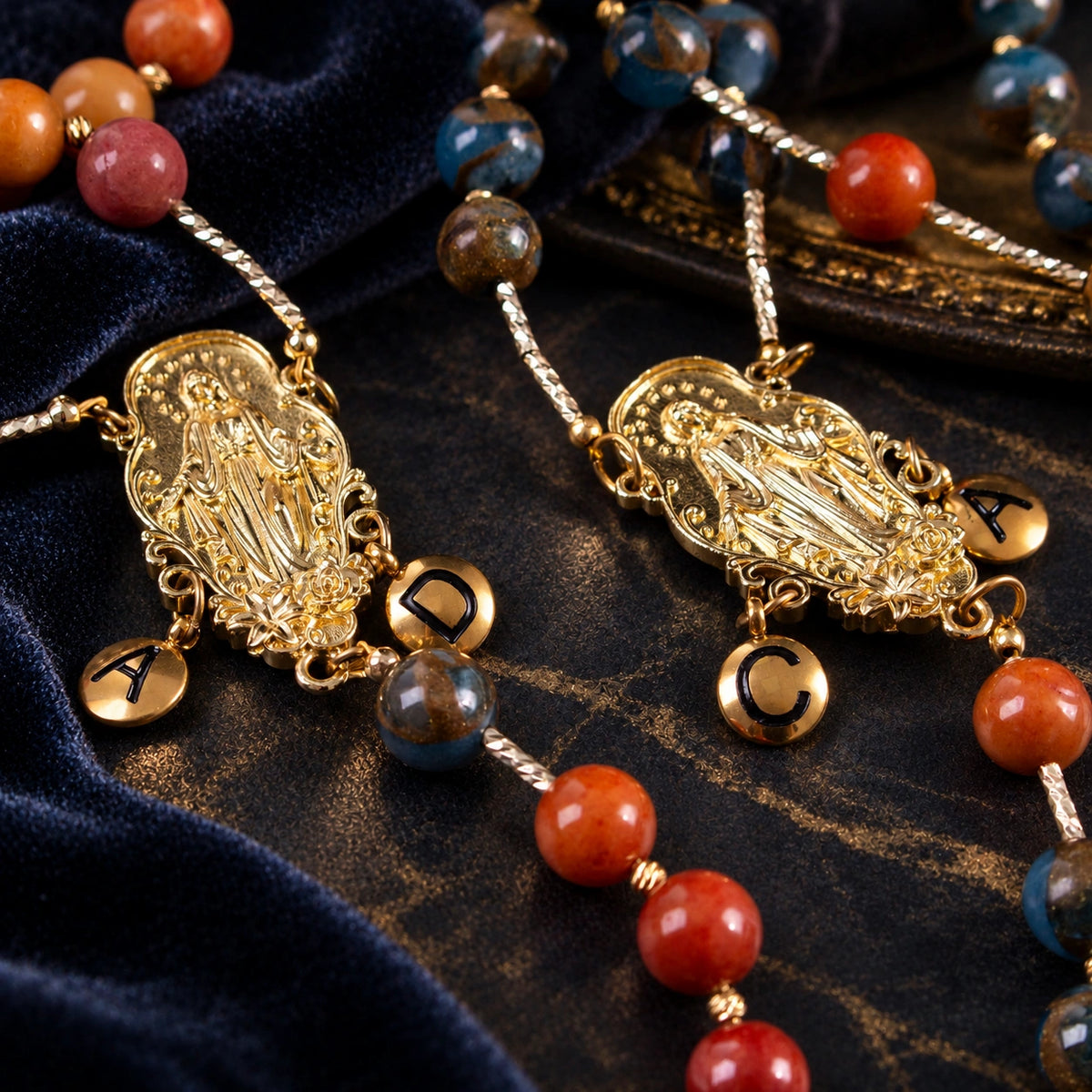 Close-up of Catholic wedding rosaries featuring gold Marian centerpieces, personalized letter charms, and elegant crucifix pendants.
