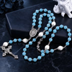 Blue Catholic rosary featuring peaceful blue prayer beads, white accent beads, silver details, and a classic crucifix pendant.