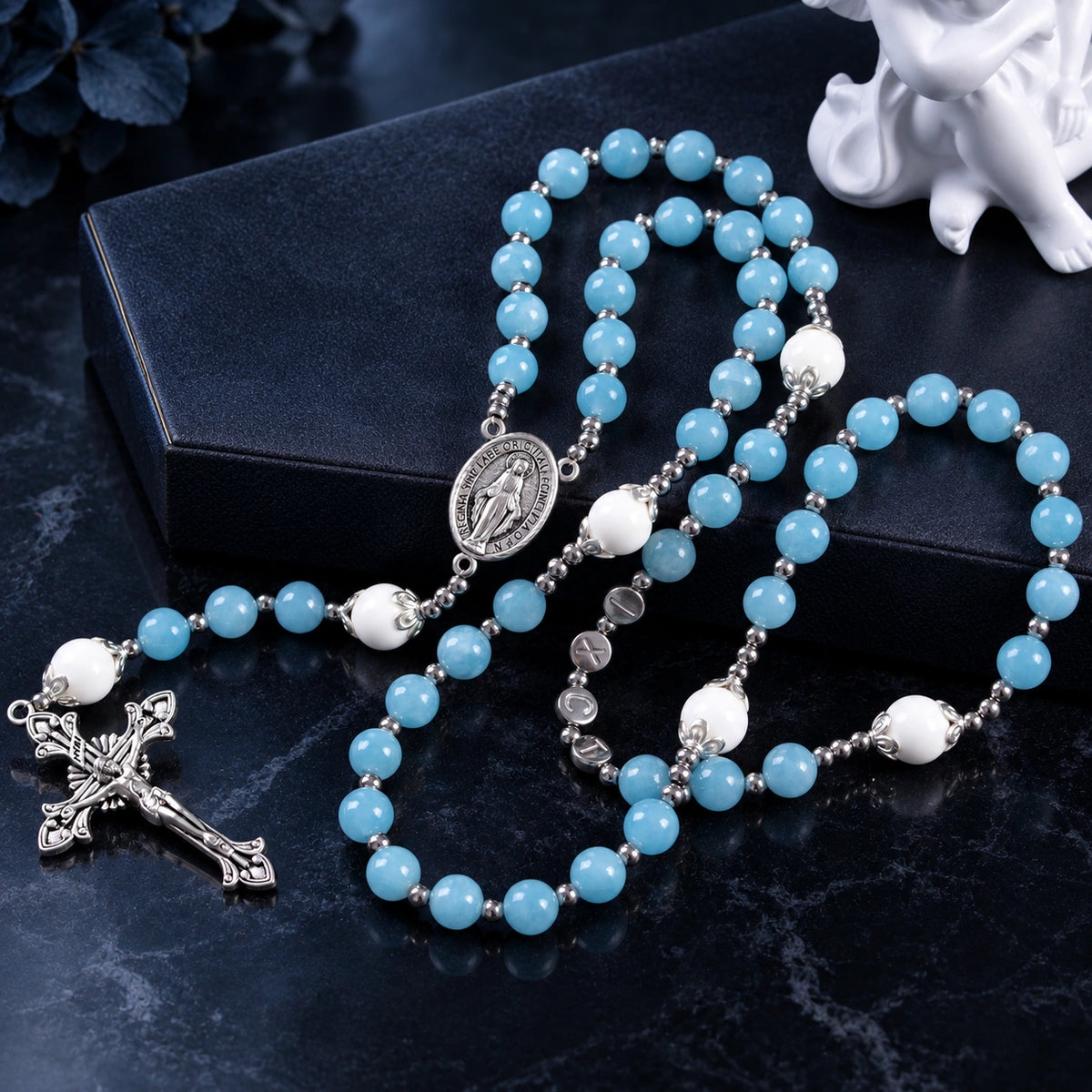 Blue Catholic rosary featuring peaceful blue prayer beads, white accent beads, silver details, and a classic crucifix pendant.