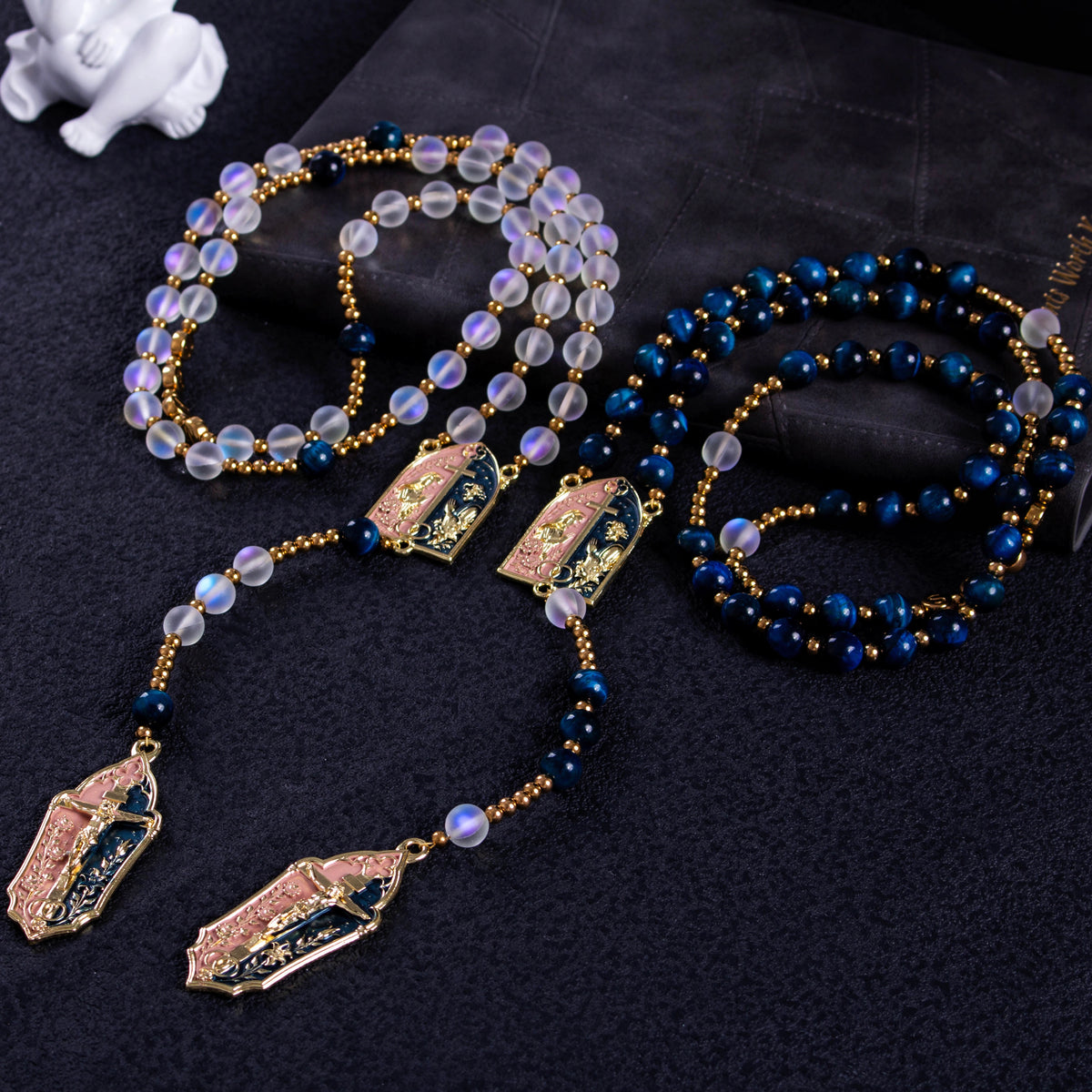 Handmade Catholic wedding rosary set with deep blue and translucent beads, gold crucifixes, and Marian centerpieces for bride and groom.