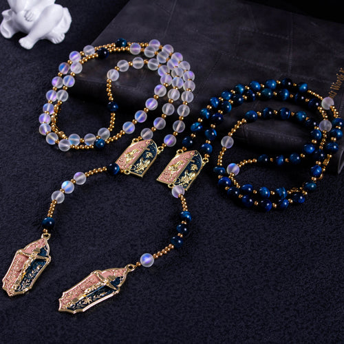Handmade Catholic wedding rosary set with deep blue and translucent beads, gold crucifixes, and Marian centerpieces for bride and groom.