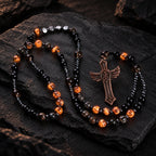 Men’s Catholic prayer beads with black and amber UV reactive beads, dark metallic details, and bold bronze crucifix.
