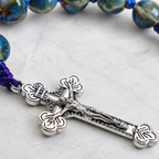 Silver crucifix pendant on handmade Catholic prayer beads with colorful cord and ceramic-style beads for daily devotion.