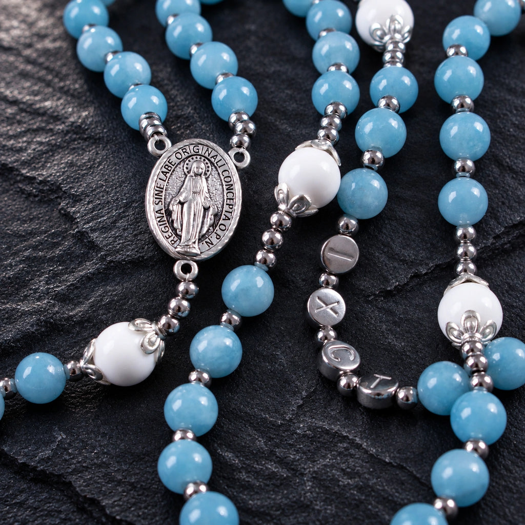 Marian centerpiece on a blue Catholic rosary with silver spacer details and handmade prayer bead design.