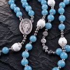 Marian centerpiece on a blue Catholic rosary with silver spacer details and handmade prayer bead design.