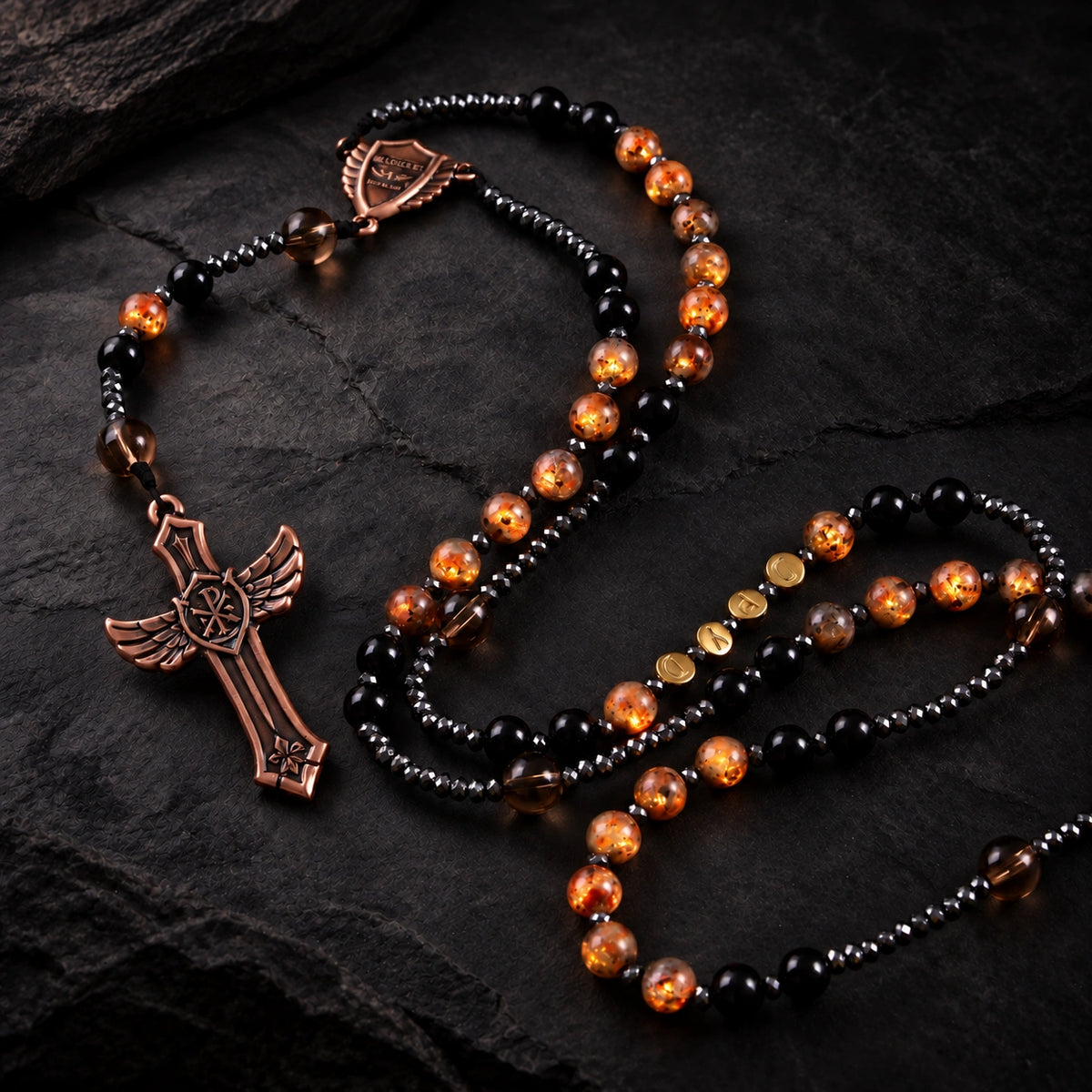 UV Guardian Rosary featuring sunlight-reactive amber beads, black prayer beads, smoky accents, and a bronze cross pendant.