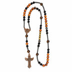 Handmade men’s Catholic rosary with black beads, UV color-changing amber accents, dark spacers, and bronze crucifix.