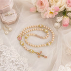 Pink pearl bridal rosary wrapped around a white wedding bouquet, designed as a meaningful Catholic wedding keepsake for the bride