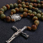 Close-up of handmade men's Catholic rosary featuring earthy natural stone beads, woven cord details, and a detailed silver crucifix.