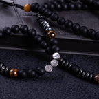Black Catholic rosary for men displayed on a dark prayer book, designed for daily prayer, reflection, and devotion.