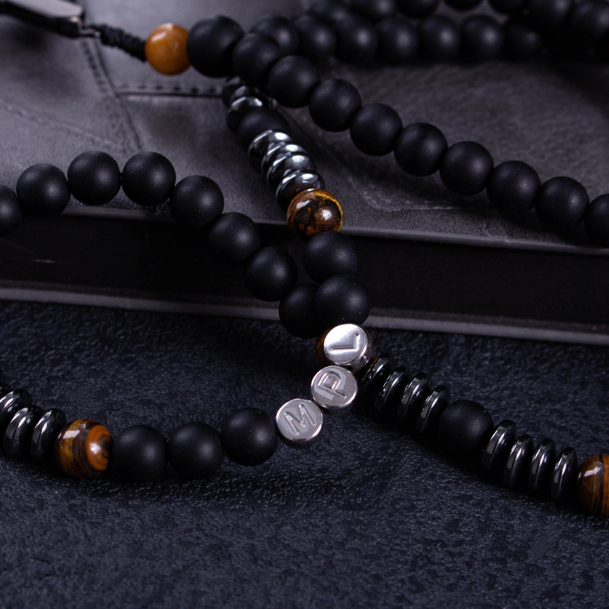 Black Catholic rosary for men displayed on a dark prayer book, designed for daily prayer, reflection, and devotion.