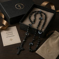 Men’s black Catholic wedding rosary with gray and black beads, crescent accent details, and a black cross, styled as a meaningful groom gift.