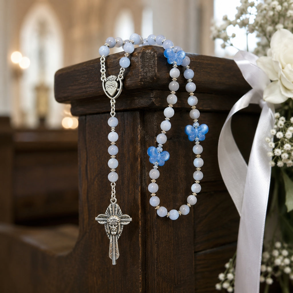 Bride holding a soft blue Catholic rosary wrapped around a white wedding bouquet, symbolizing faith, love, and Something Blue blessing