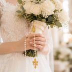 Catholic wedding rosary for bride with elegant pearl beads and gold crucifix, wrapped around a bridal bouquet as a meaningful faith keepsake for the wedding day.