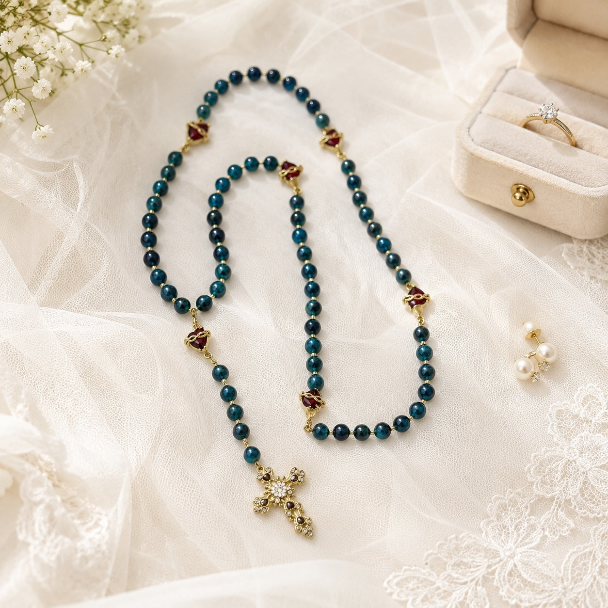 Romantic blue Catholic rosary for brides featuring gold-tone details, sacred heart accents, and a decorative crucifix, shown with wedding vow book, satin ribbon, and soft bridal flowers.