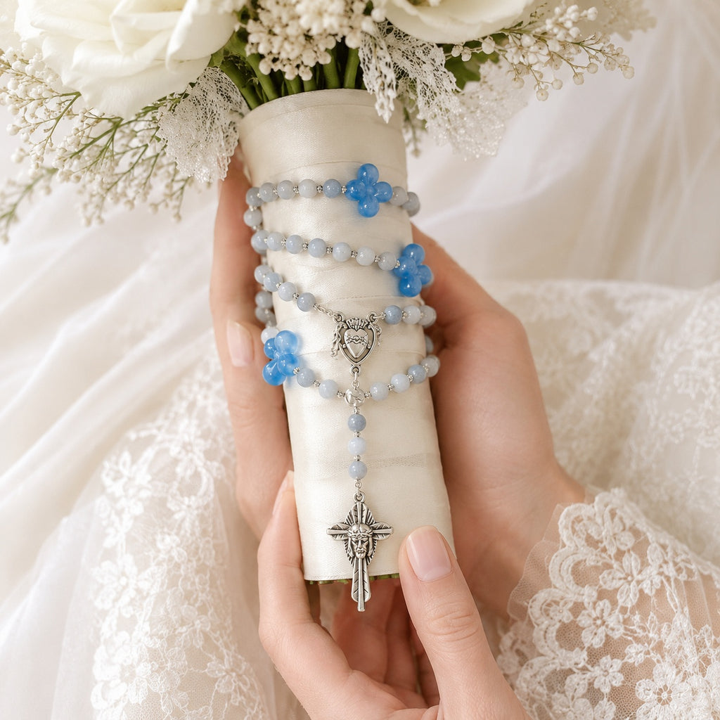 Elegant blue wedding rosary displayed with white roses and bridal lace, designed as a Catholic bride gift and marriage blessing keepsake