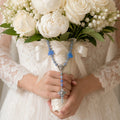 Blue bridal bouquet rosary with flower beads, silver-tone crucifix, and devotional heart medal for a Catholic wedding keepsake