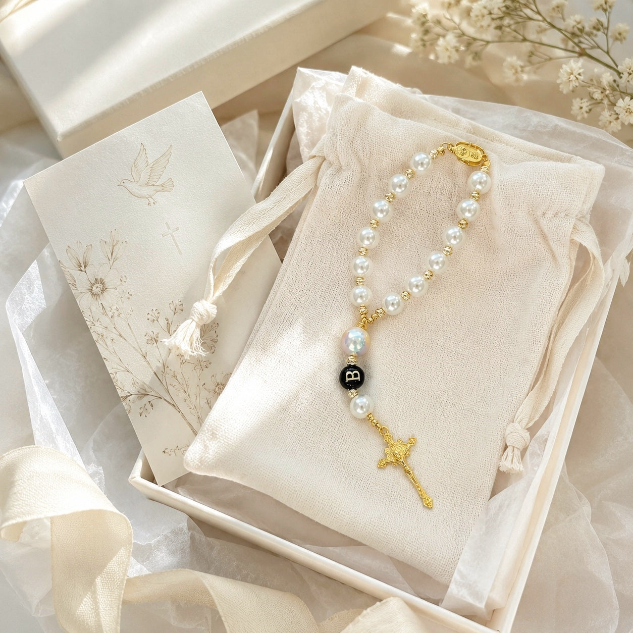 Elegant Catholic car rosary with pearl beads, gold-tone details, and crucifix hanging from a steering wheel as a travel prayer reminder