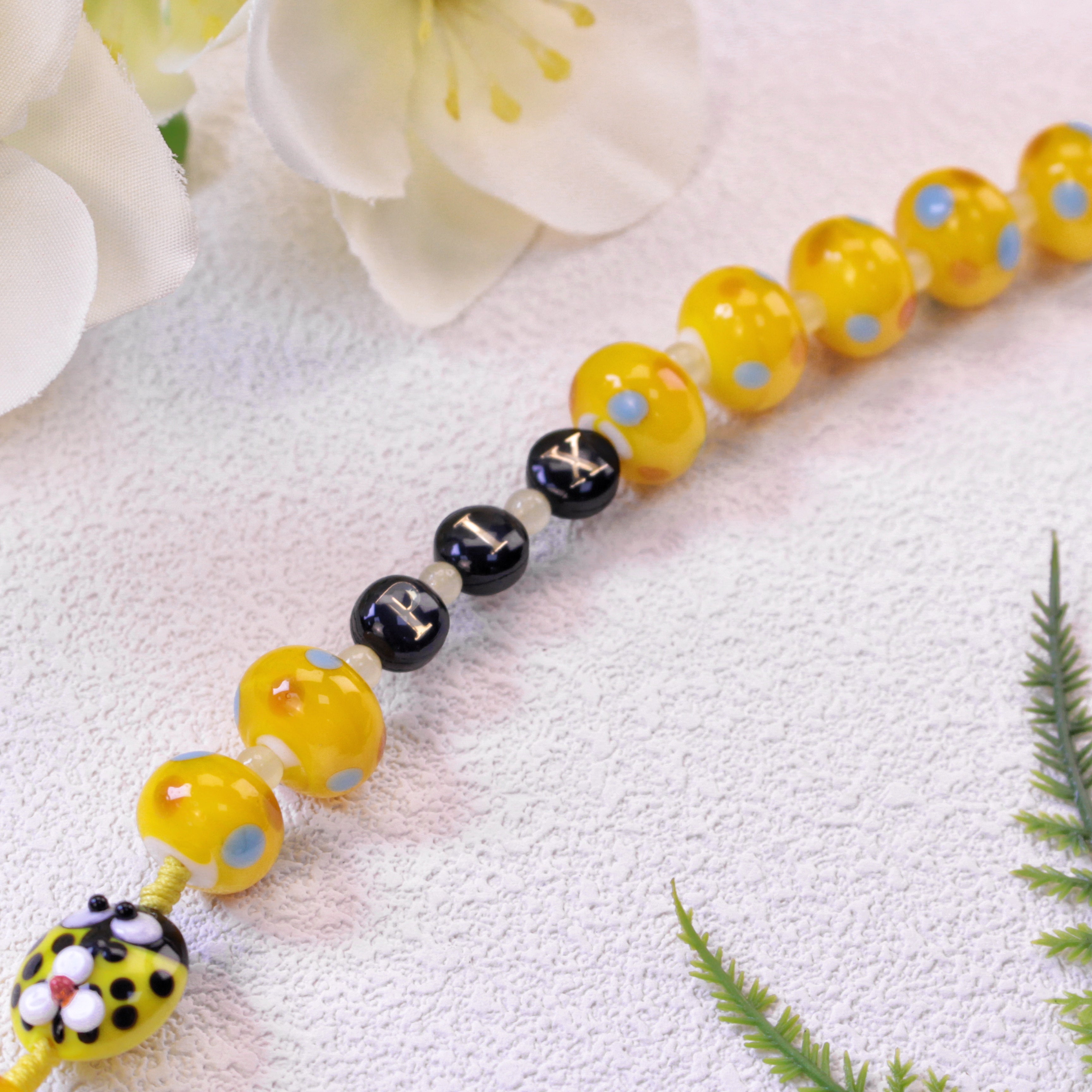 Handcrafted children's rosary with yellow beads, ladybug decorations, and Christian cross pendant for daily prayer and meaningful Catholic keepsakes.