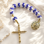 Blue and white Catholic prayer beads featuring ceramic-style beads, religious medal, and crucifix for personal devotion and spiritual reflection.