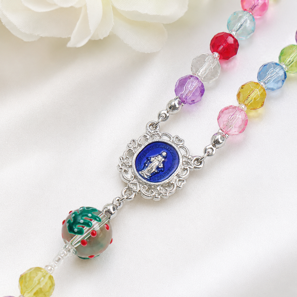Close-up of a colorful Catholic rosary with transparent beads, decorative religious elements, and a silver crucifix pendant.