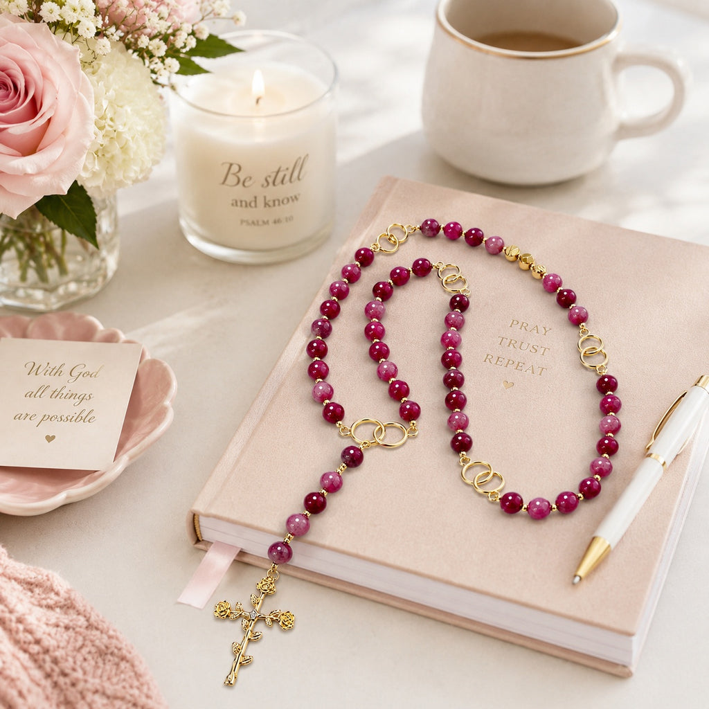 Close up view of handmade women's Catholic rosary with polished gemstone beads, gold accents, and detailed cross pendant