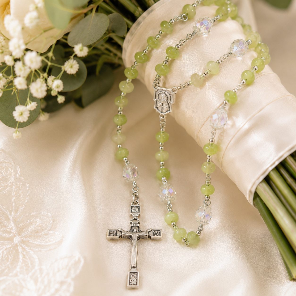 Green Catholic rosary wrapped around a wedding bouquet with white roses, eucalyptus, and satin ribbon for a bride