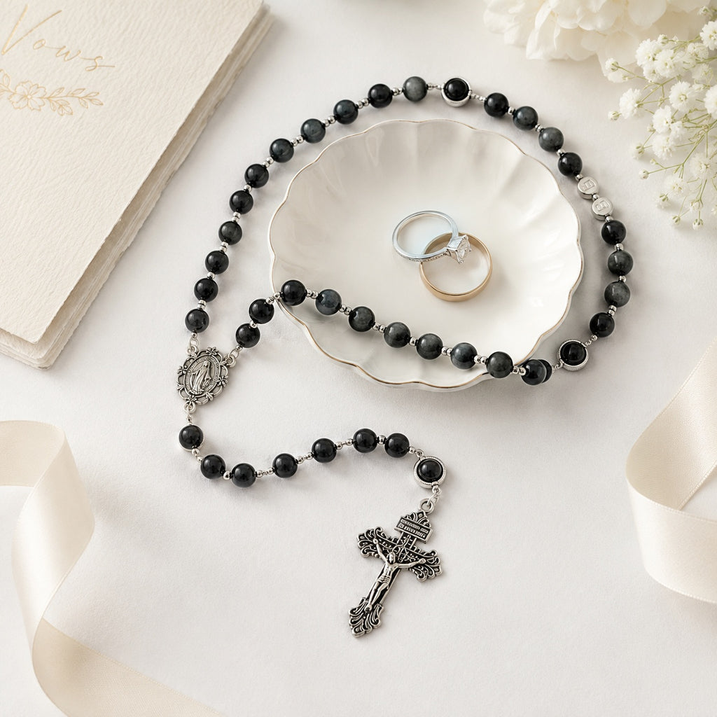 Catholic wedding rosary for groom featuring black beads, gray accents, silver crucifix, and formal wedding photography styling