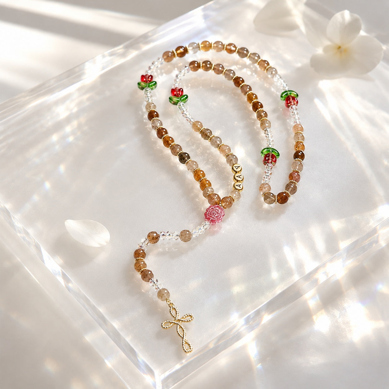 Personalized Catholic rosary for women with soft natural-style beads, floral accents, custom letter beads, and a delicate gold crucifix