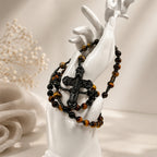 Handmade tiger eye rosary for men featuring black prayer beads, metallic spacers, and a detailed black crucifix
