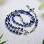 Handcrafted five decade Catholic rosary featuring deep blue prayer beads, silver-tone medals, Marian center piece, and crucifix for personal devotion.