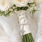 Soft pastel bridal bouquet rosary with silver crucifix, handmade-style prayer beads, and gentle wedding floral styling