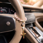 Sparkling pink steering wheel rosary with crystal-style beads, pearl accents, gold crucifix, and custom initial charm