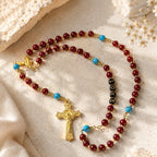 Handmade red rosary beads with gold-tone crucifix and blue turquoise-style accents, styled as a confirmation gift