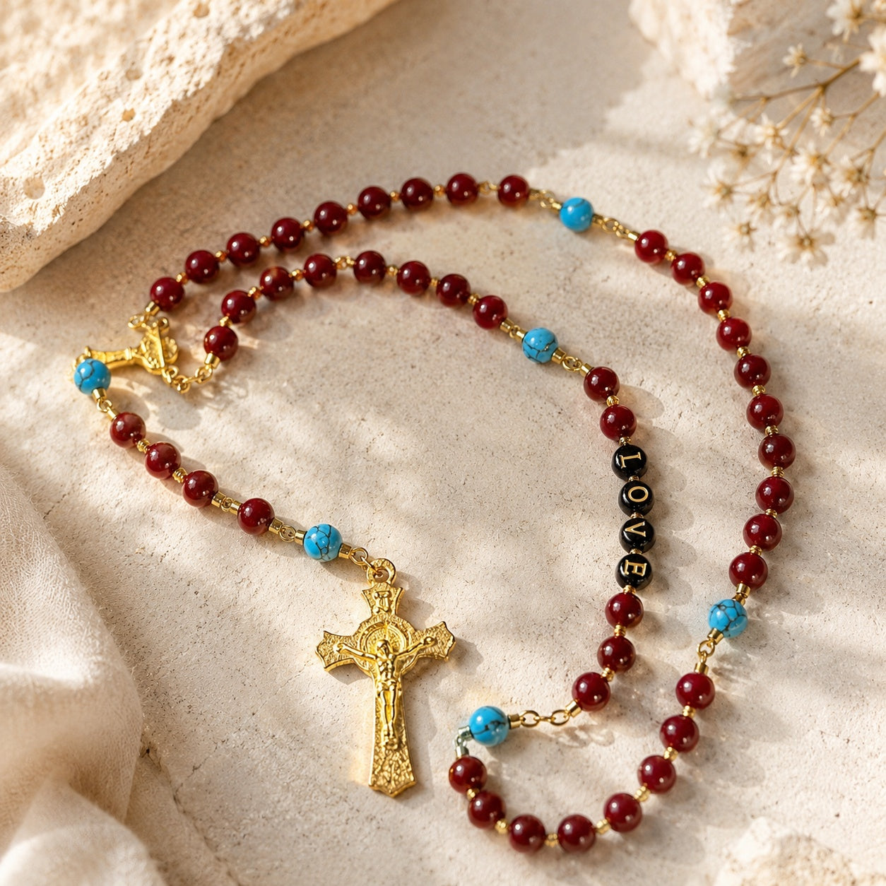 Handmade red rosary beads with gold-tone crucifix and blue turquoise-style accents, styled as a confirmation gift