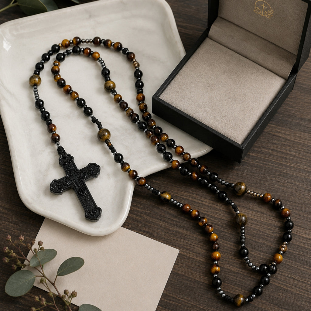 Tiger eye Catholic rosary beads for men with a black crucifix displayed on a white ceramic dish and dark wooden table